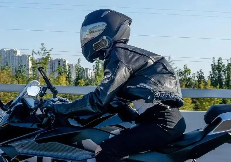 Motociclista con casco integral y el intercomunicador X30 Mesh puesto al costado